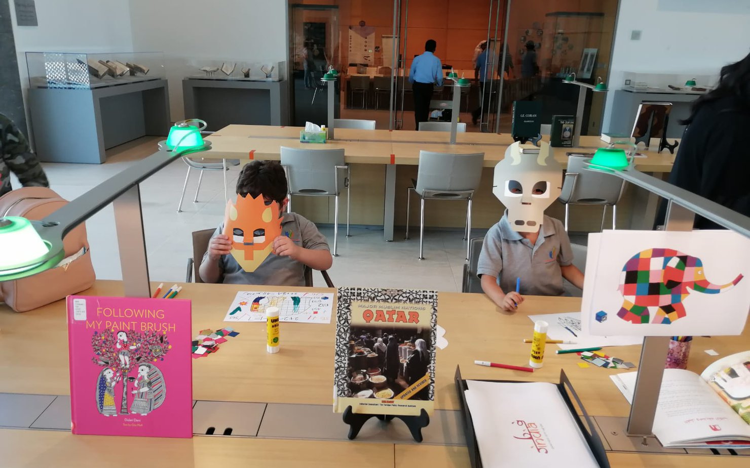 Children making masks out of chart-paper and holding it up against their face